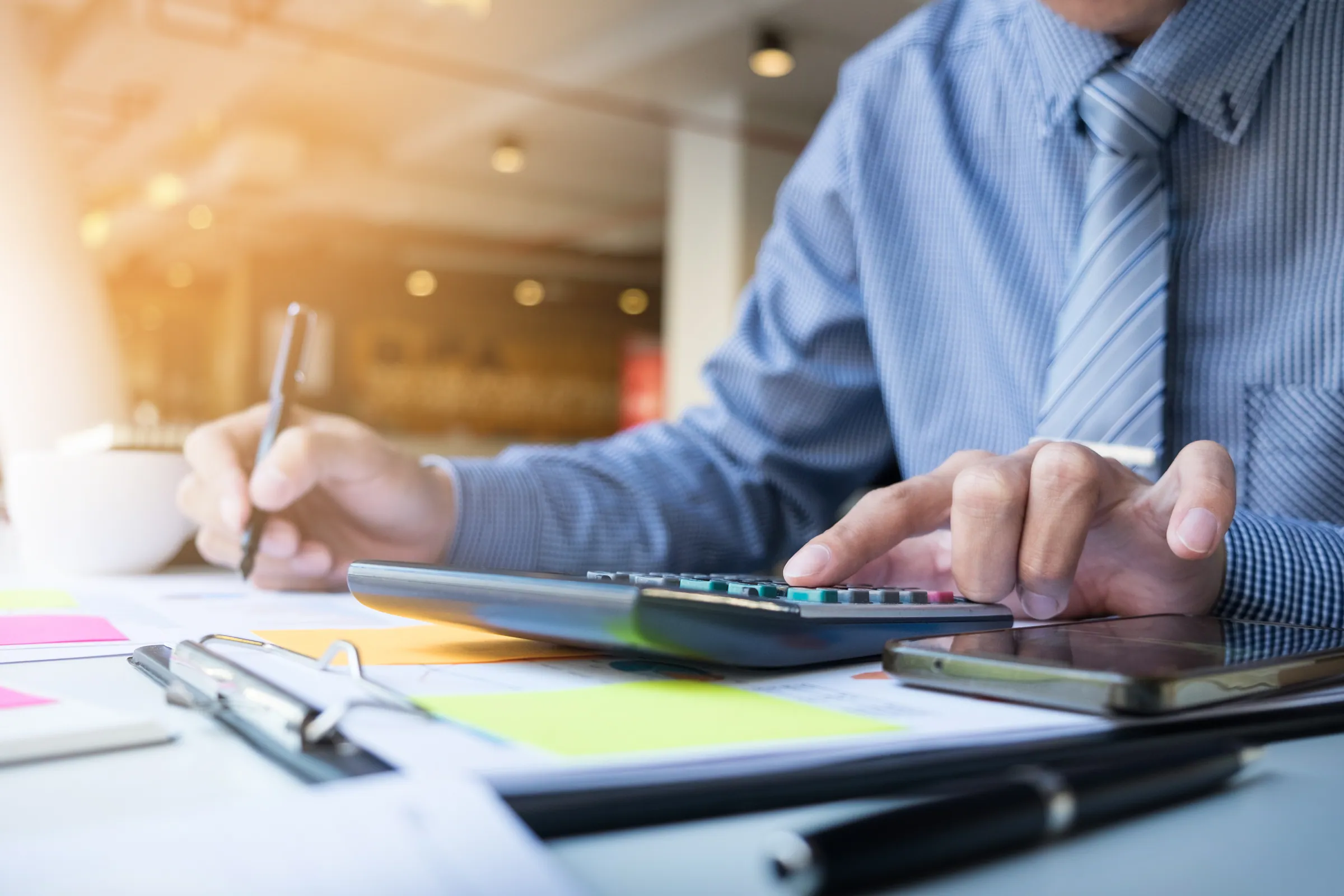 Finance professional working through invoices and figures at a desk