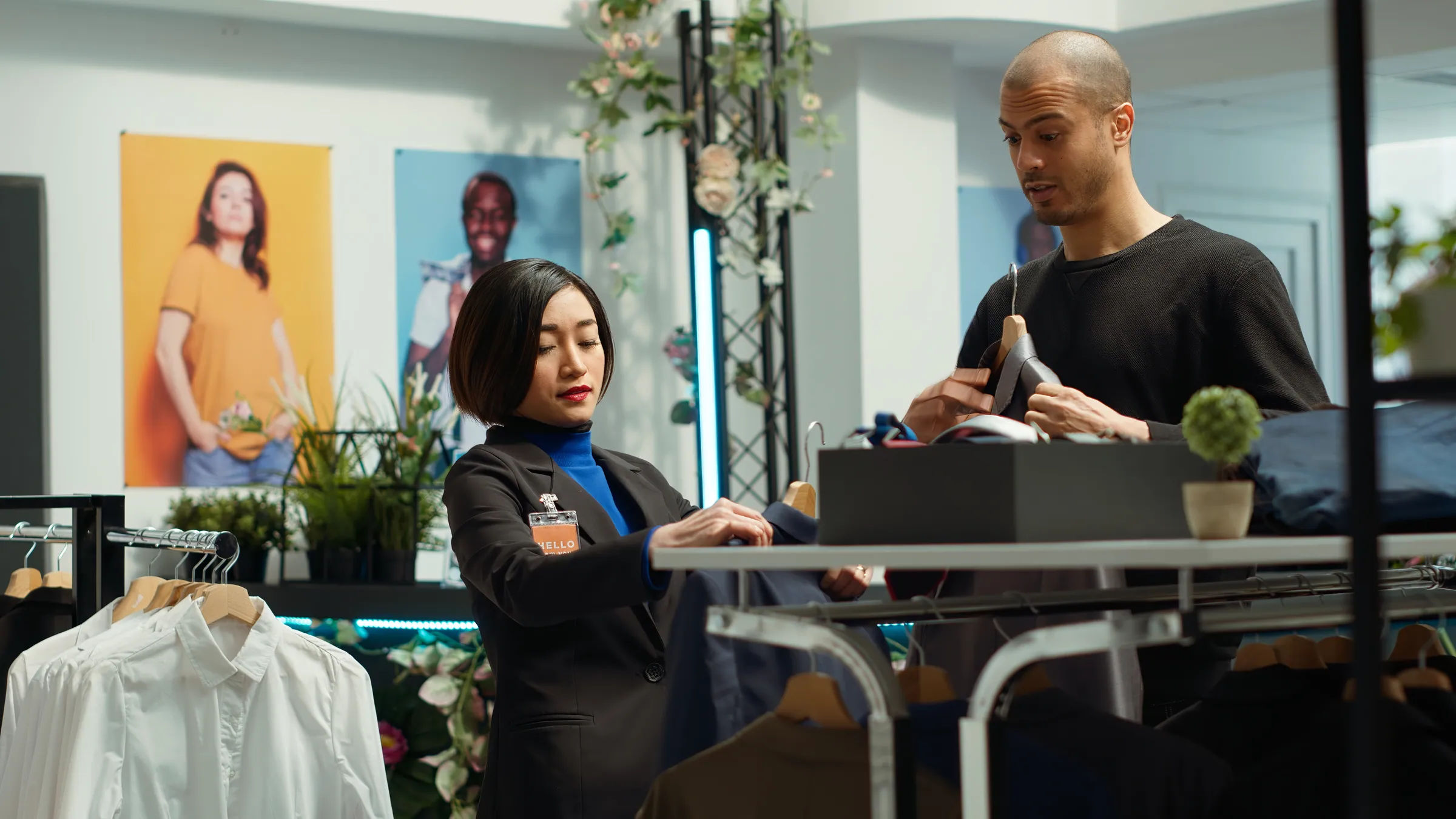 Store associate in a blazer advising a customer on the shop floor, representing retail and consumer operations data