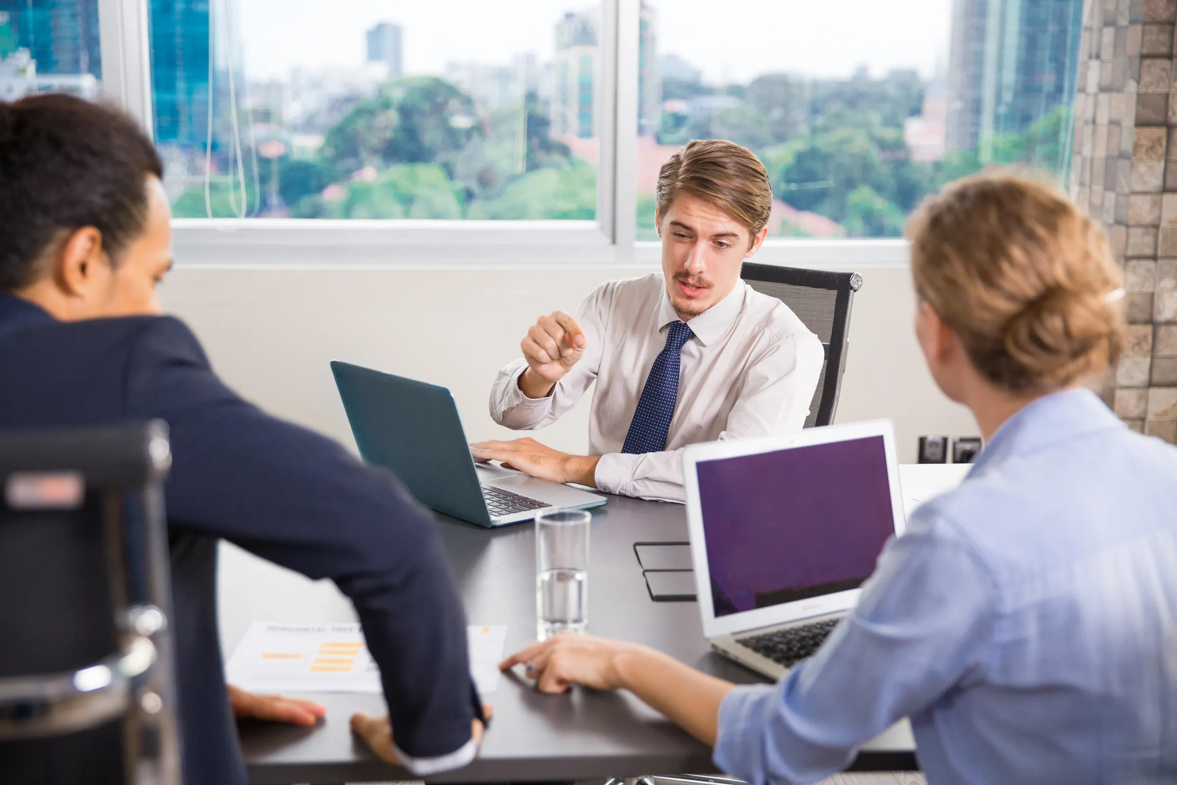 Colleagues in shirts and ties working through a laptop review