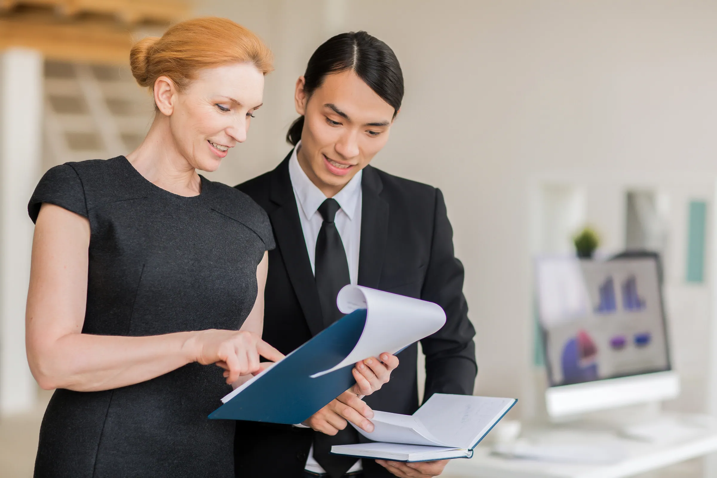 Two colleagues in business dress reviewing figures