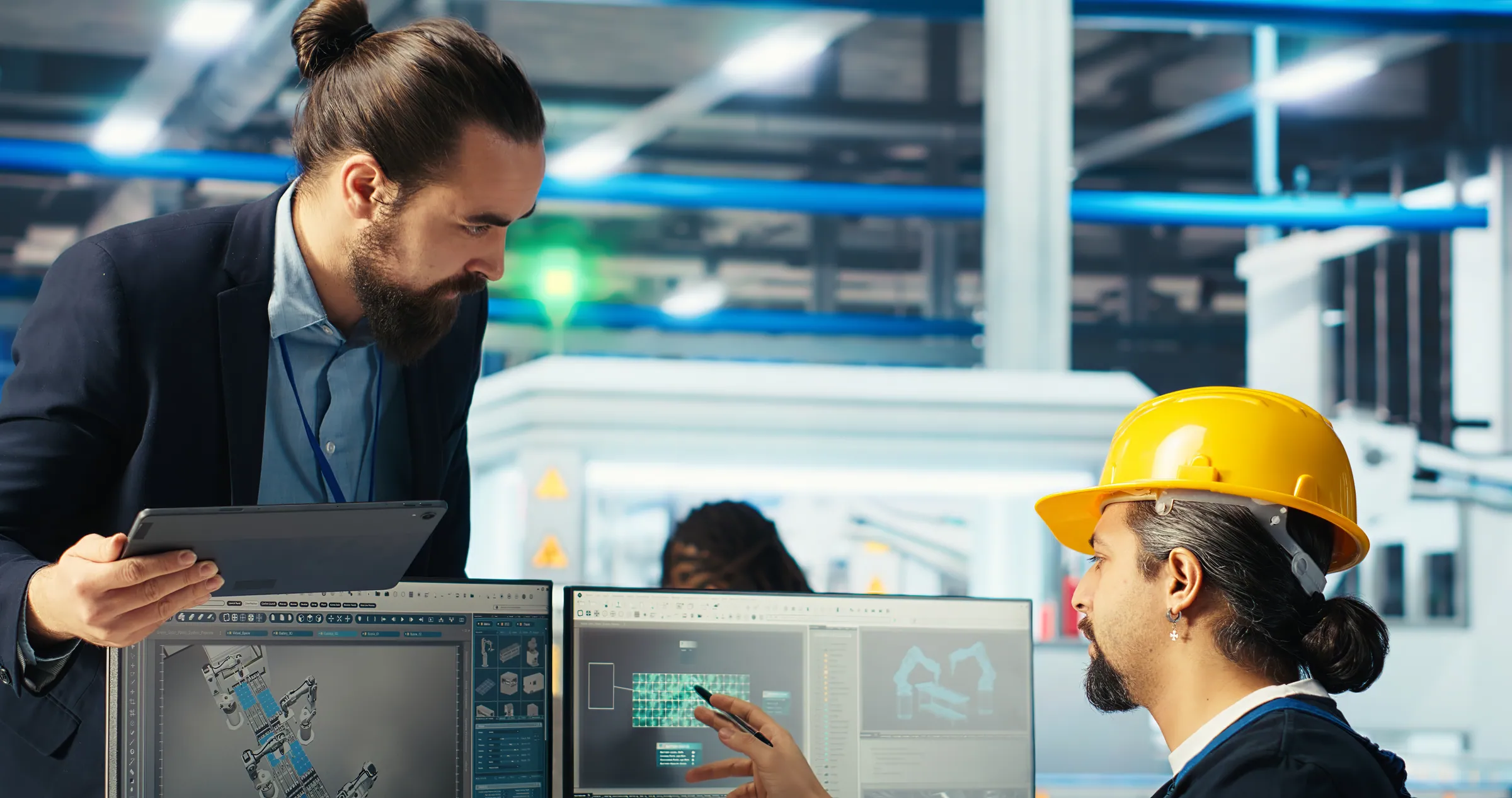 Engineer with a tablet beside panel design screens