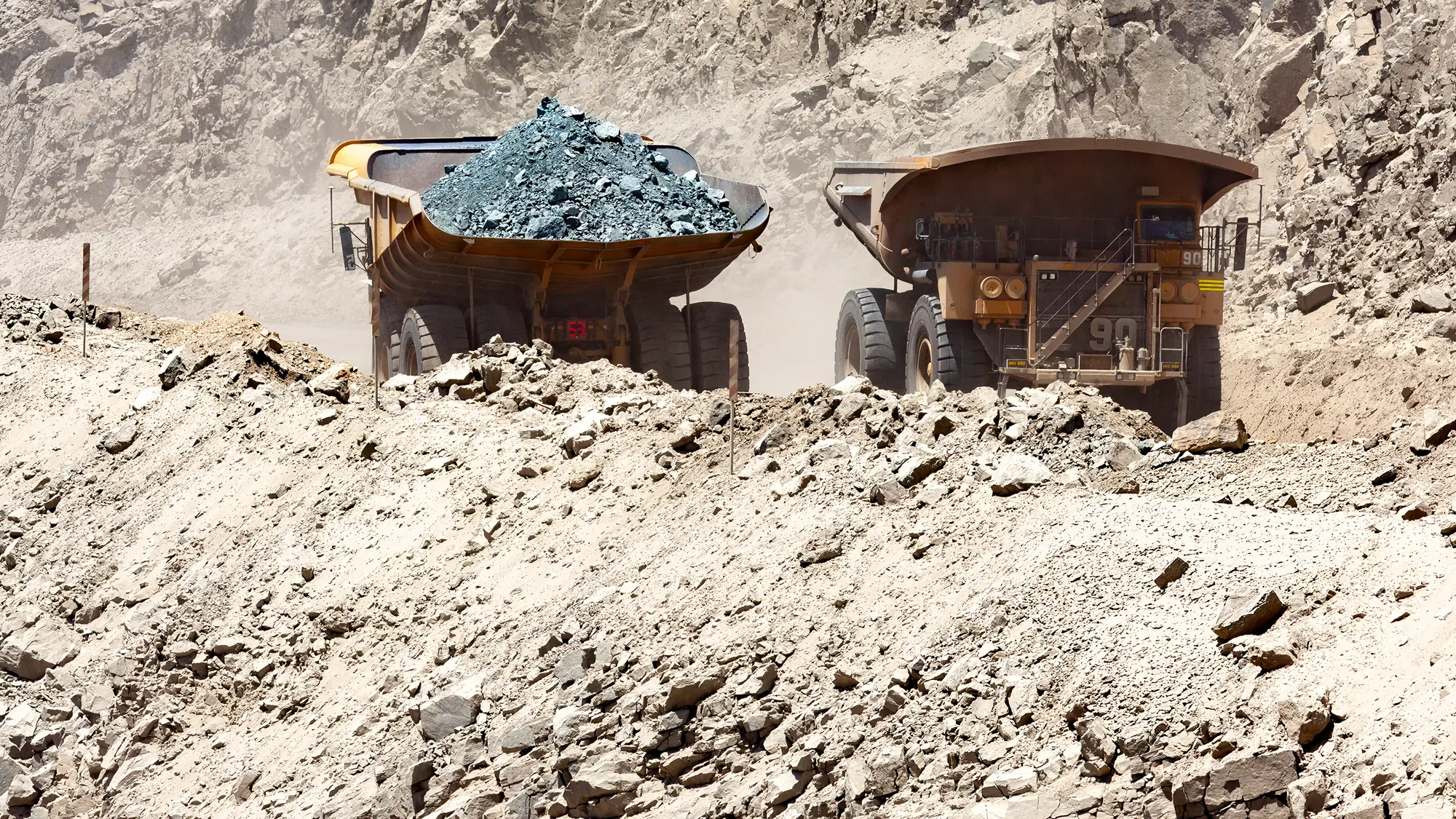 Haul trucks carrying copper ore at an open-pit mine