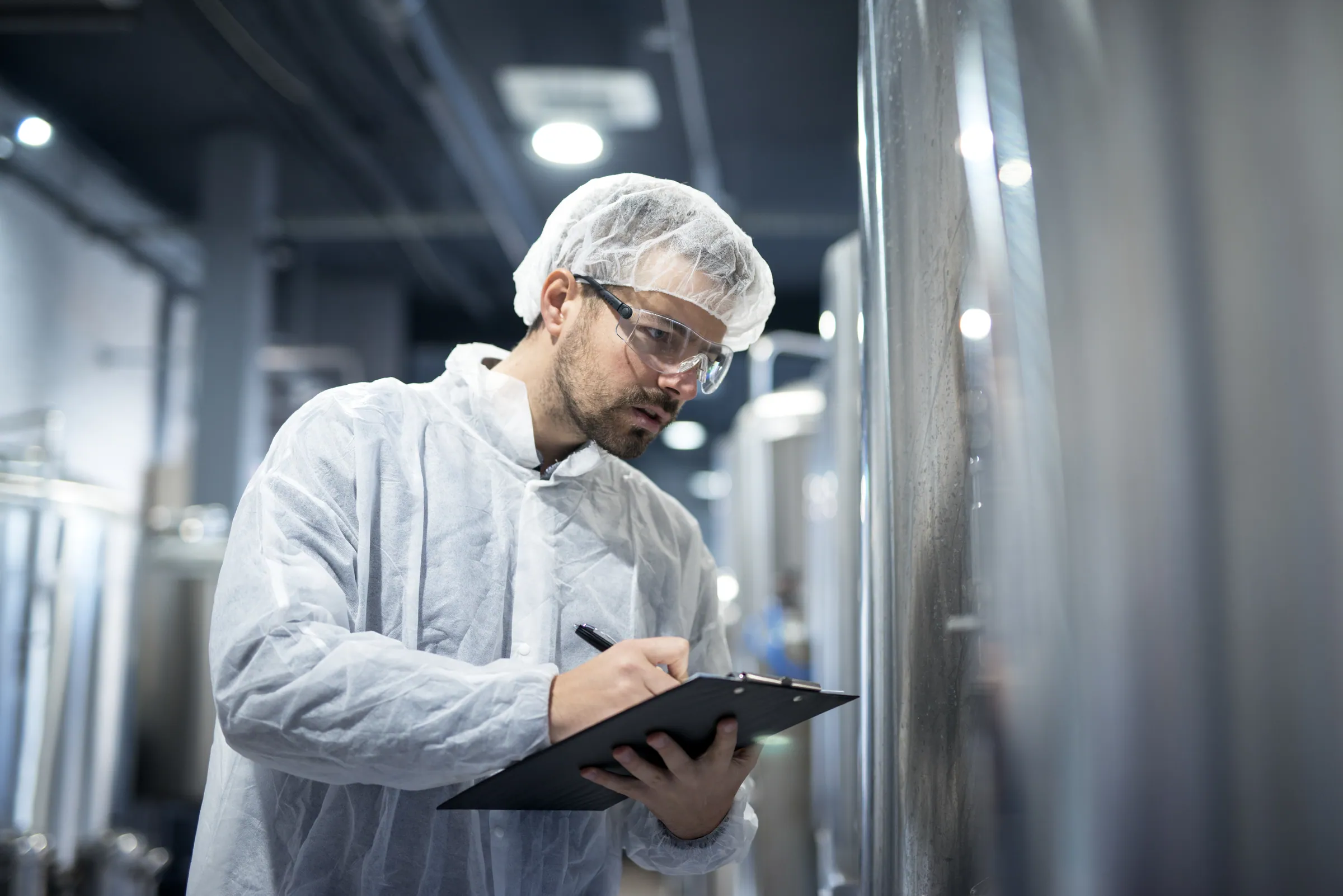 Technologist recording checks against a processing vessel