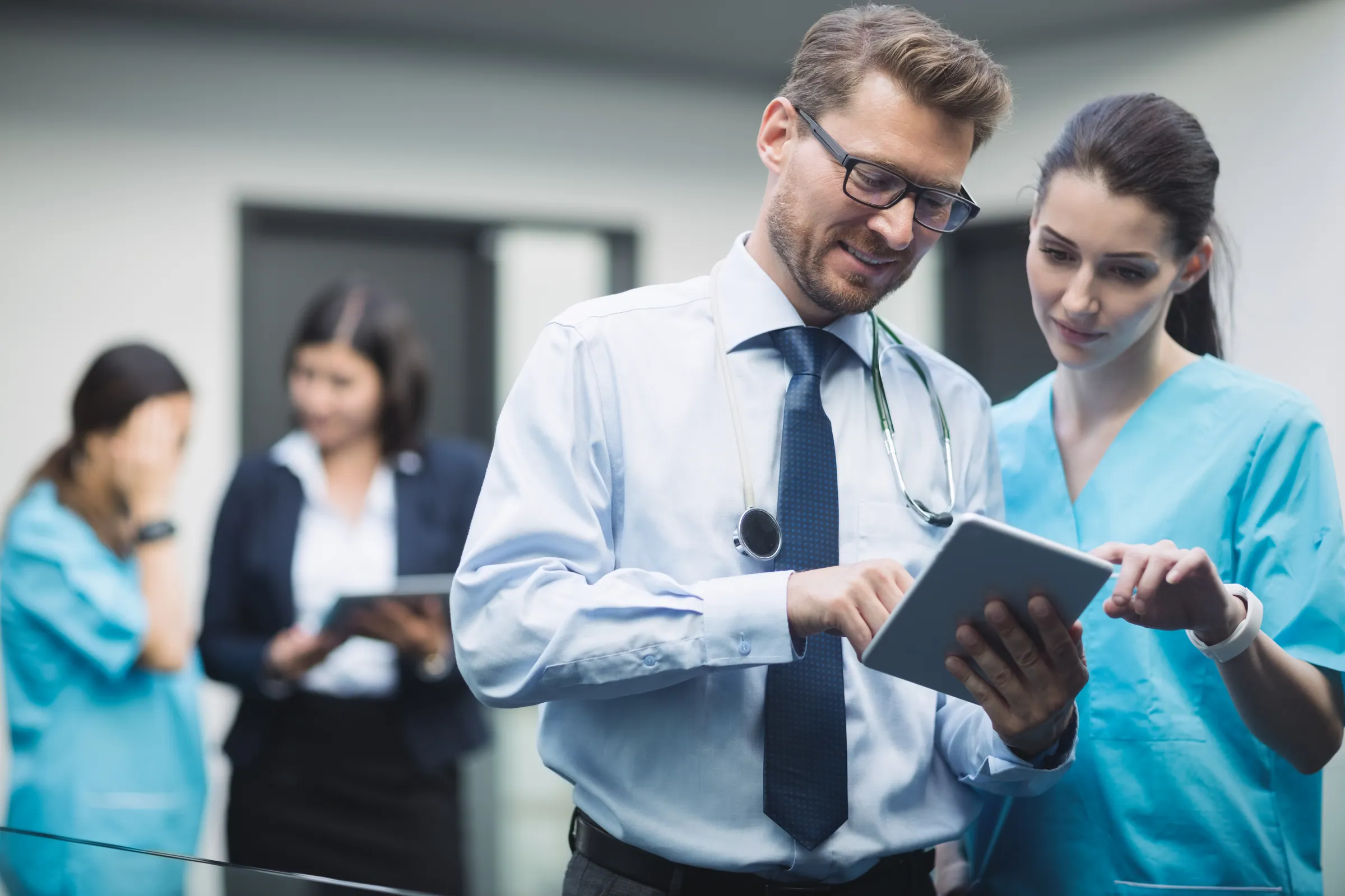 Doctor and nurse reviewing records on a tablet