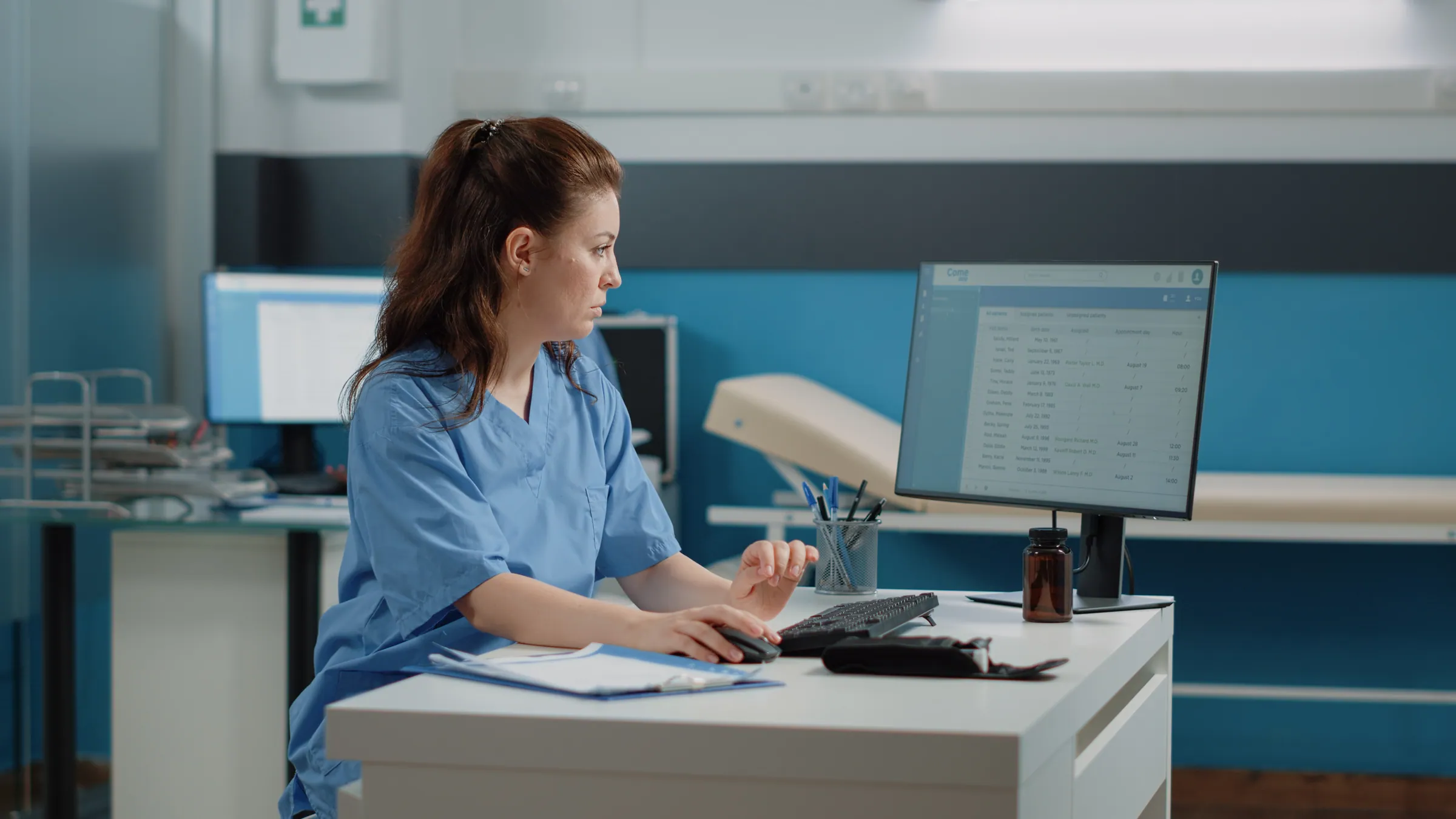 Medical administrator processing records at a desk