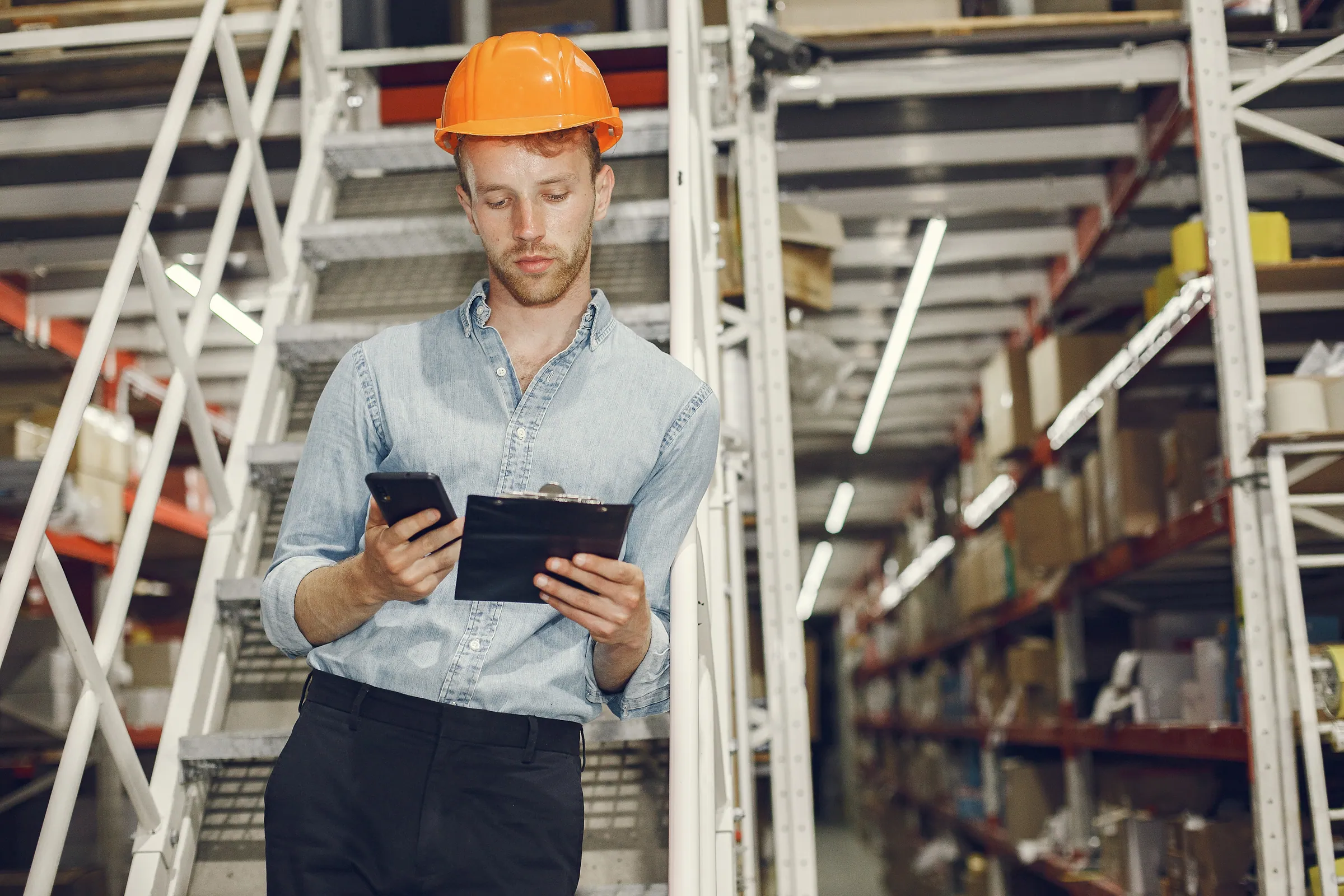 Supervisor in hard hat and shirt on a factory floor